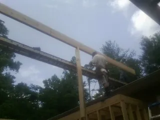 Carpenter setting a ridge beam over a new addition frame — Ice Dam Removal by Roofing Brothers in Apple Creek