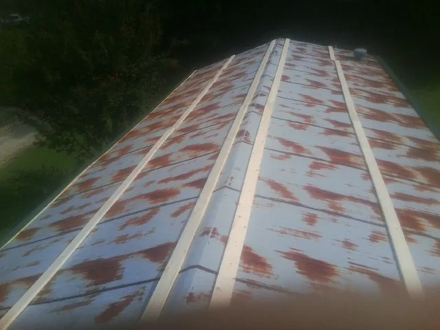 Rusted metal roof panels with new wood purlins before replacement — Storm Damage Roof Repair in Apple Creek by Roofing Brothers