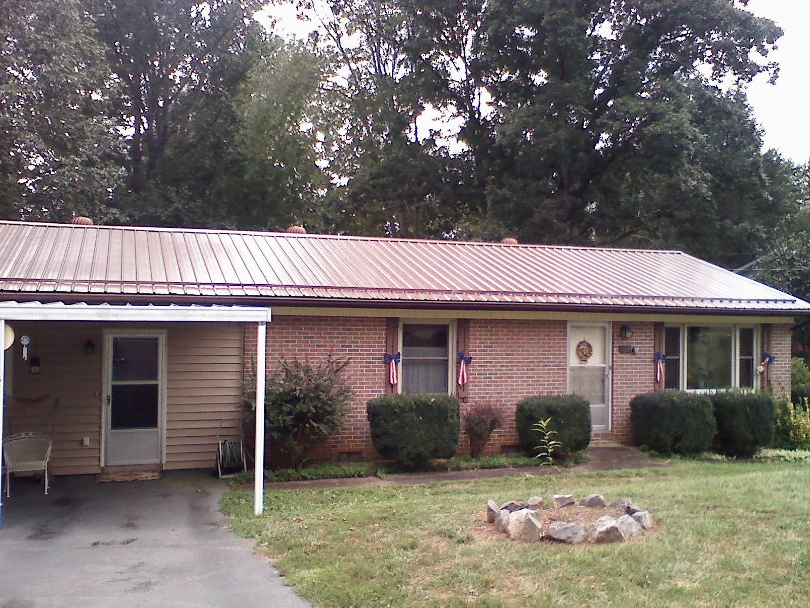 Bronze metal roof and carport on a brick ranch home — Roof Repair work by our crew in Apple Creek