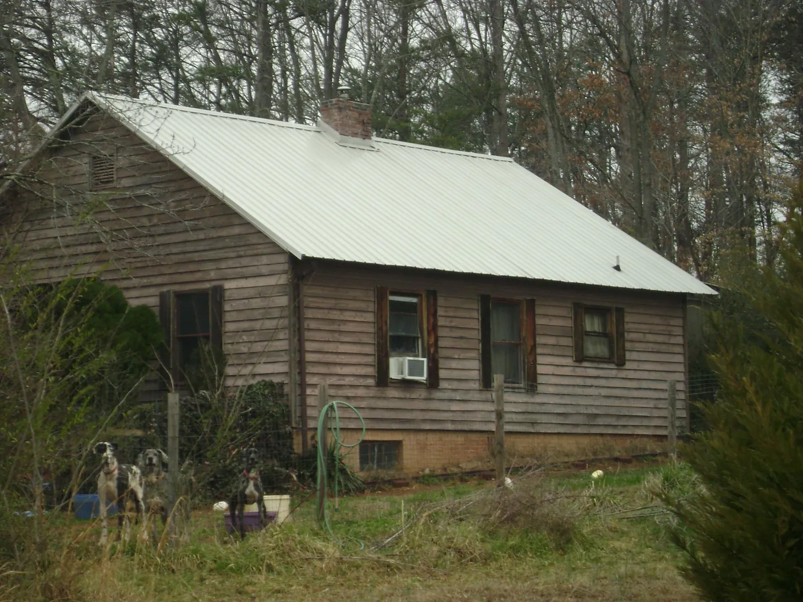 White metal roof on an old wood sided farmhouse, from a Metal Roof Installation job in Apple Creek